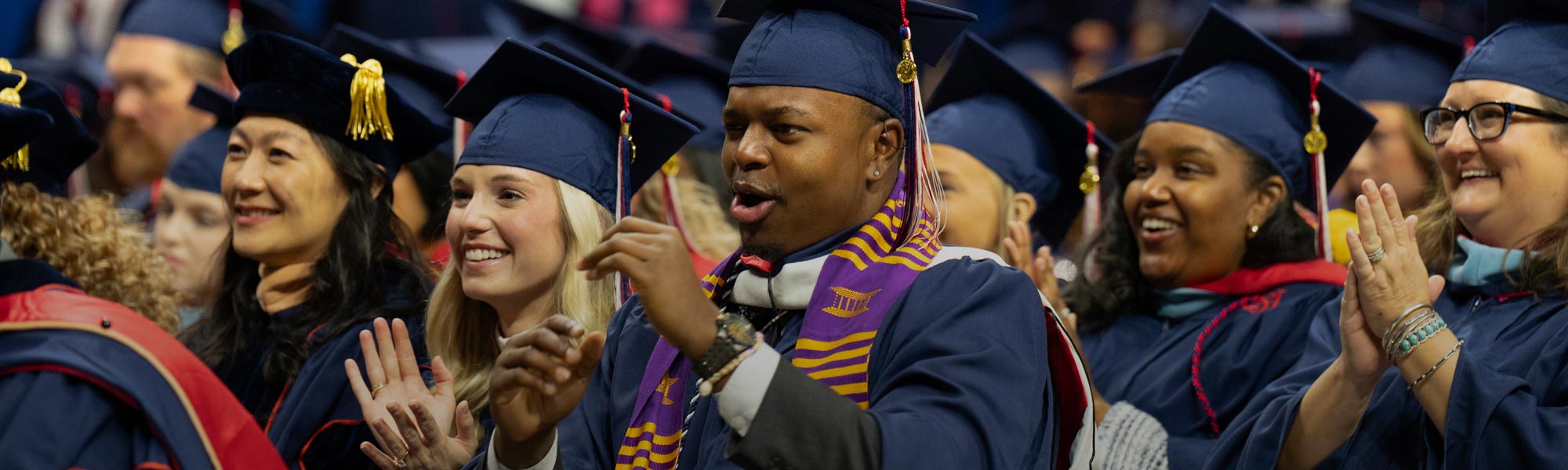 Male and female students celebrating commencement