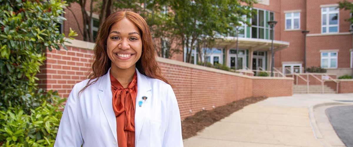 Image of Physician Assistant Studies student looking in another student's ear.