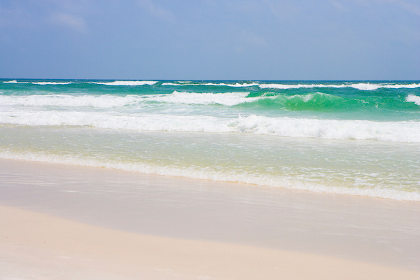 turquoise waves gently crashing onto sandy beach