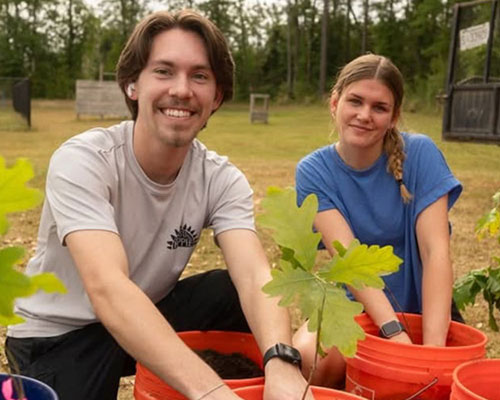 students preparing buckets with tree saplings for earth day 2025