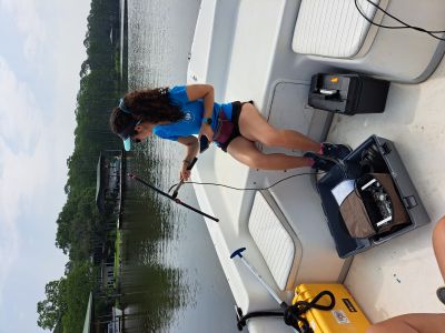 Ph.D. student using research equipment on the stern of a boat