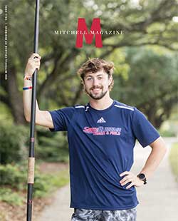 MCOB studentin track and field shirt holding pole.