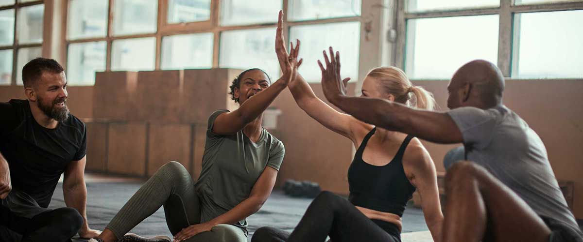 People high fiving outside after a workout.