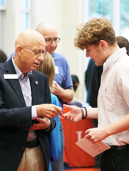 Employer handing a business card to a student.