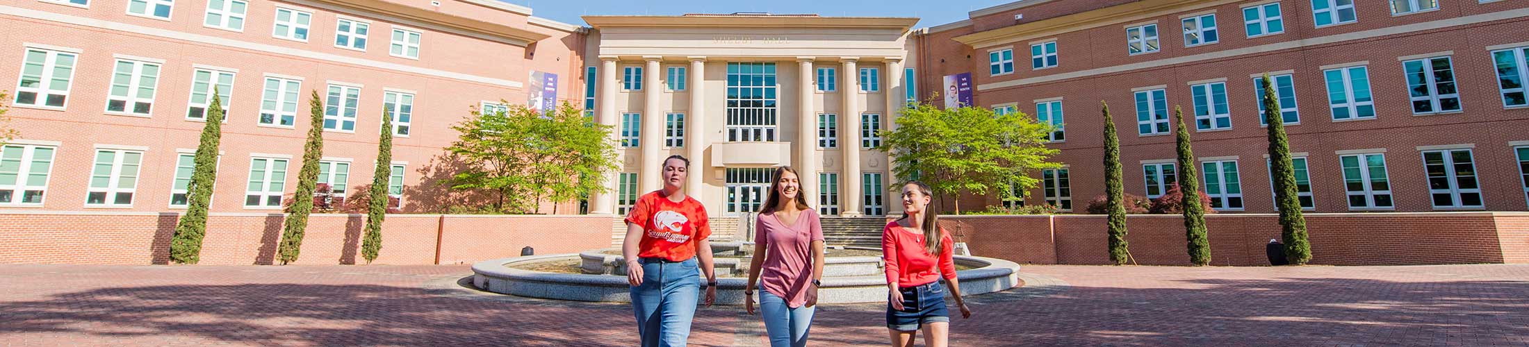 Three students walking in front of Shelby Hall.