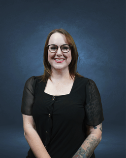 girl smiling at camera with blue background